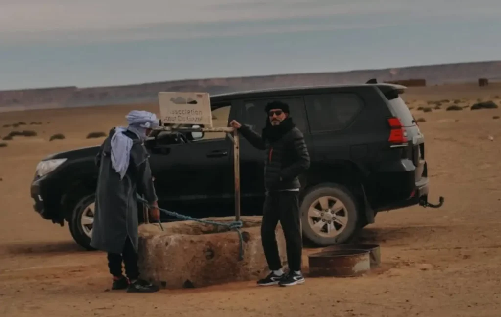 A traveler and a nomad at a traditional water well during a Morocco itinerary 7 days.