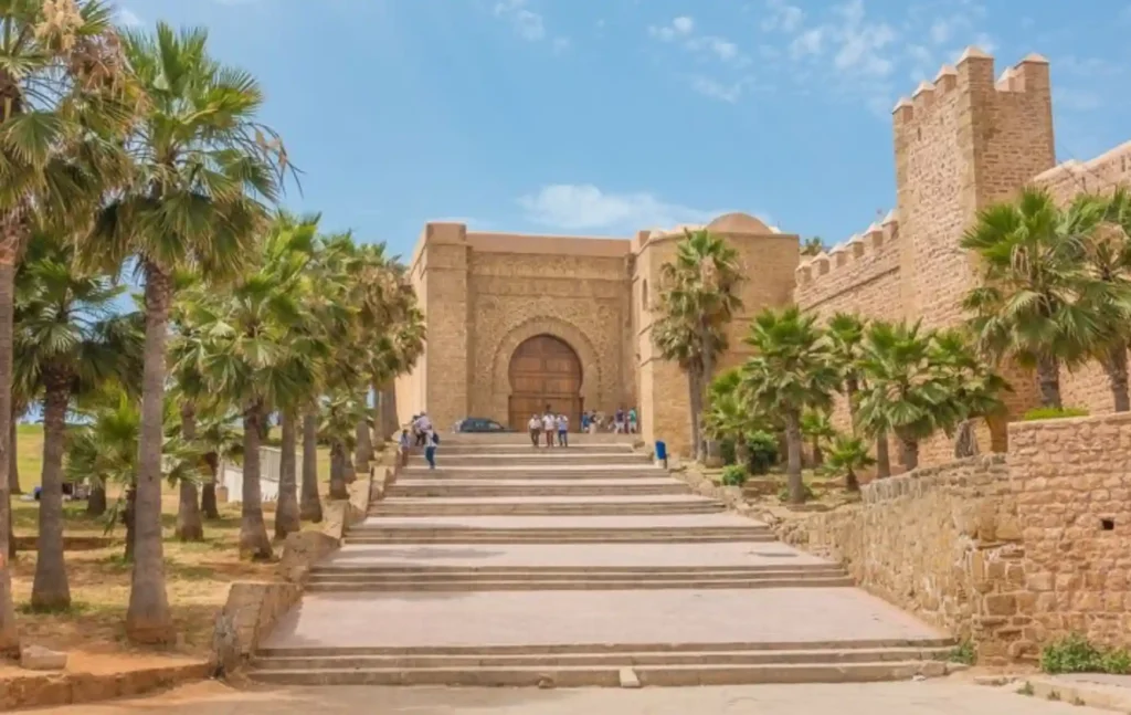 A wide view of the historic stone gate and palm trees at the Kasbah of the Udayas in Rabat, a key stop on a morocco itinerary 10 days