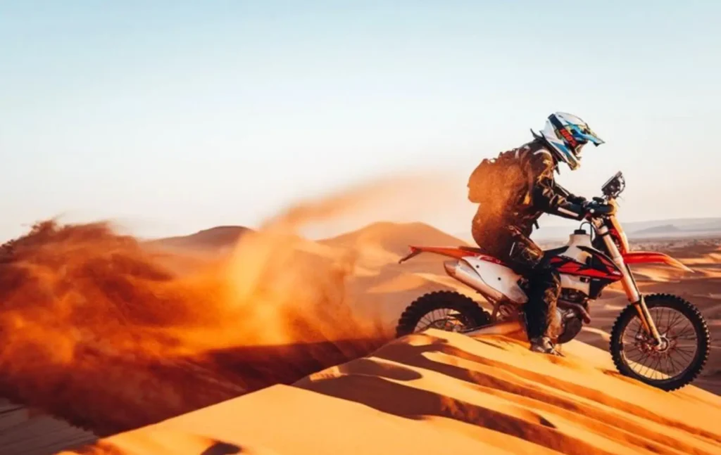 A rider on a KTM Merzouga tour kicking up sand during one of our Merzouga Desert Tours.