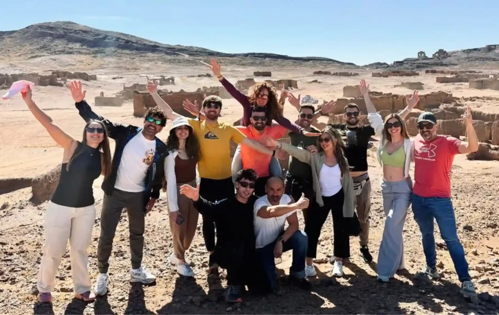 A happy group of travelers posing together at the M'ifis kohl mines during a 4 days tour from Fes to Marrakech.