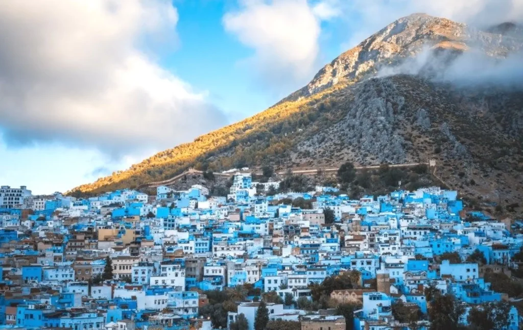 A wide landscape of the blue houses of Chefchaouen nestled at the foot of the Rif Mountains during a 6 days tour from marrakech.