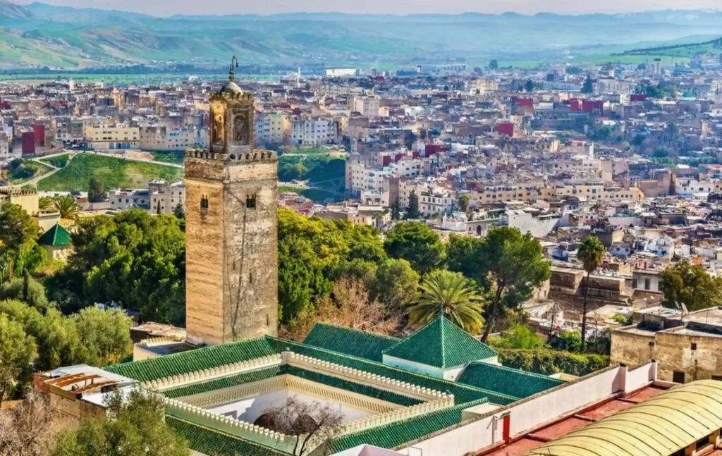 A high-angle panoramic view of the ancient Fes medina and its green-tiled roofs during a 6 days tour from marrakech.