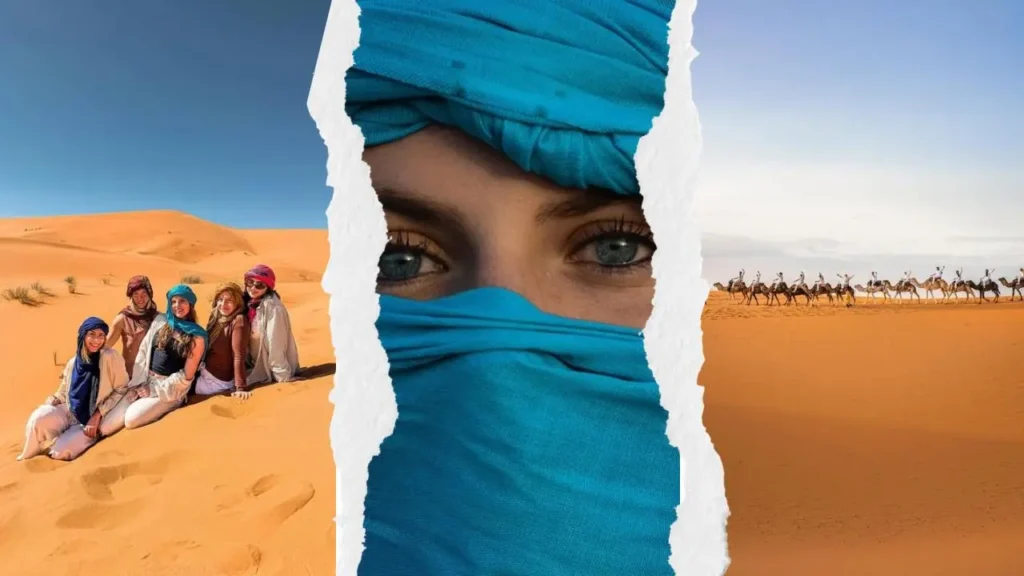 A traveler wearing a blue turban, a group of friends sitting in the sand, and a camel caravan in Merzouga during a shared 3 days desert tour from Marrakech.