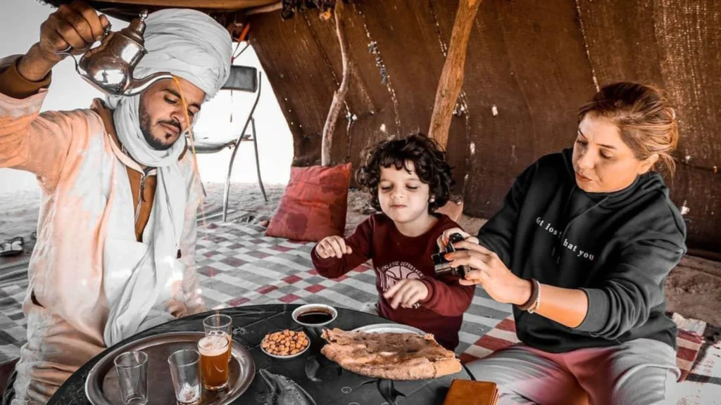A family enjoying traditional mint tea in a nomad tent during Casablanca desert tours, a memorable stop on their morocco itinerary.