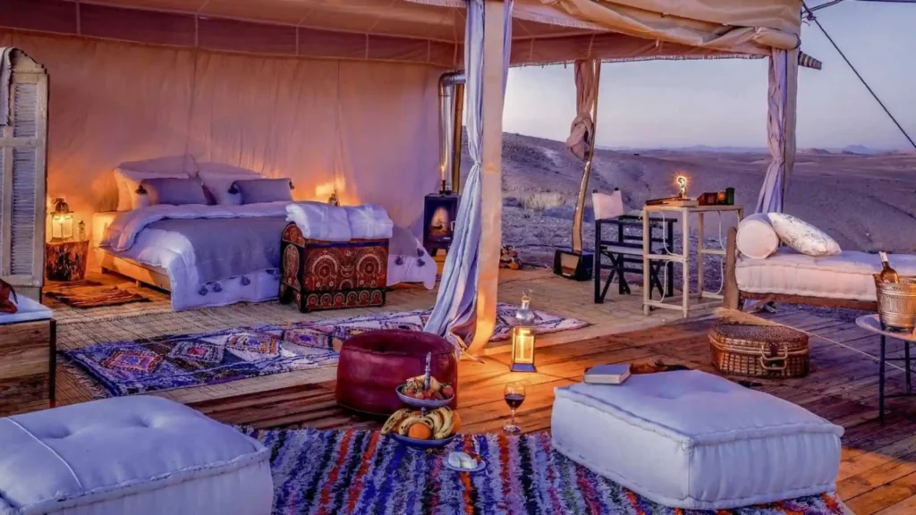 Relax in a luxurious, open-air desert tent suite with cozy seating and scenic views during our signature Morocco Honeymoon Packages for couples.