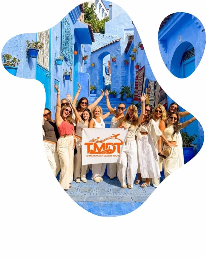 A joyful group of female students holding a To Marrakech Desert Tours banner on the vibrant blue streets of Chefchaouen during morocco student tours and morocco student trips.
