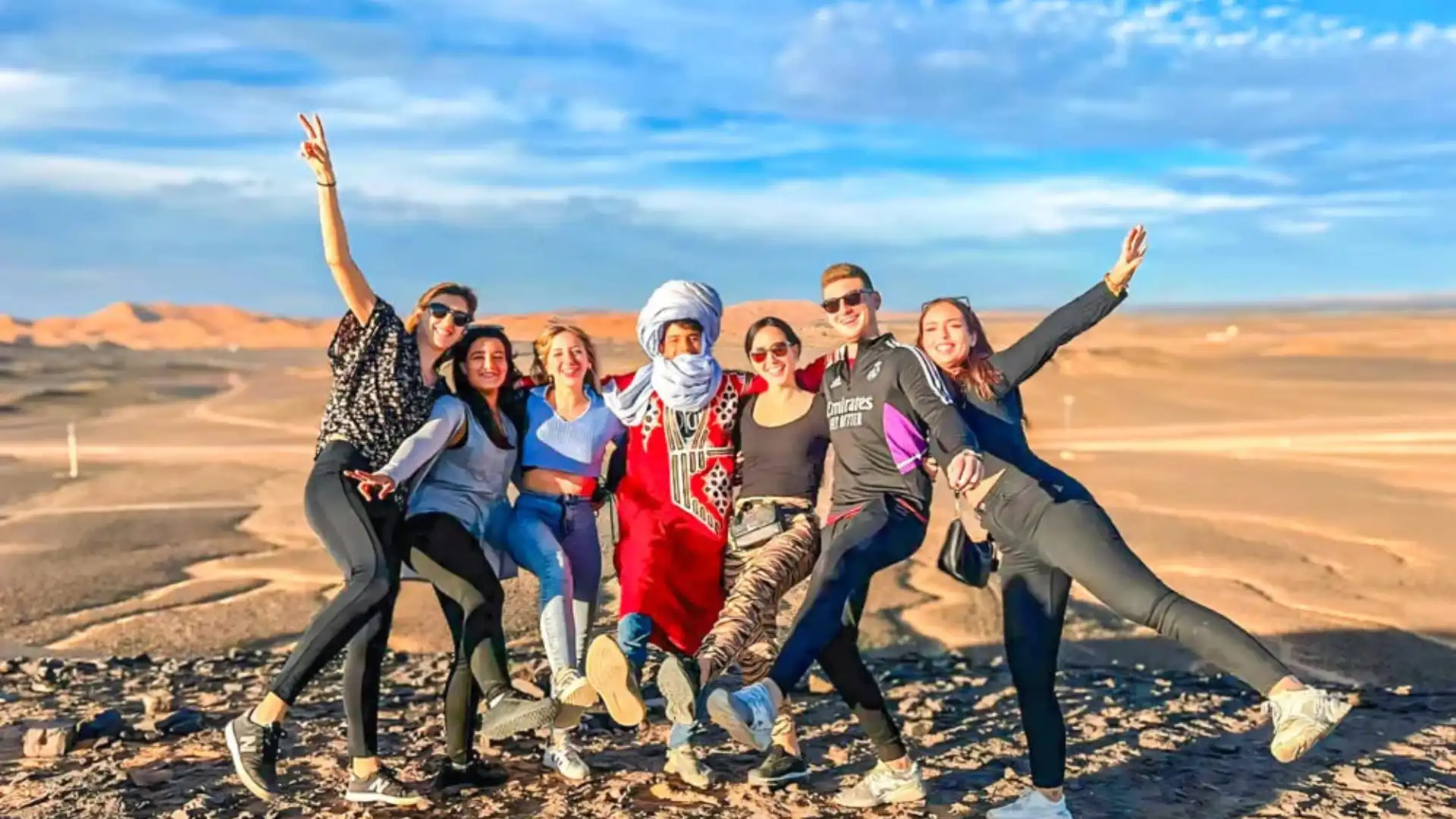 Group of travelers with their local guide on the desert near Merzouga