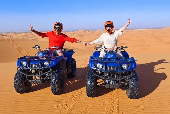 Two travelers on quad bikes in the Merzouga dunes