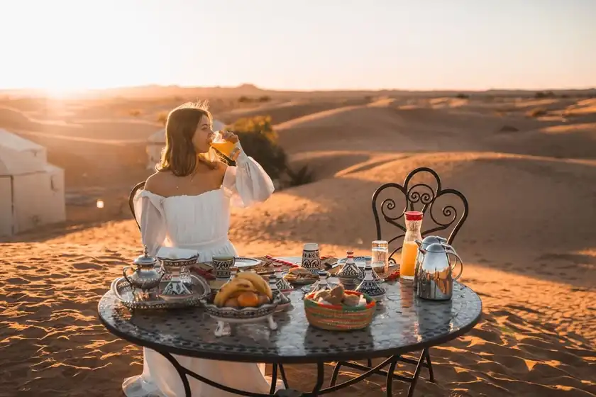 Traveler enjoying breakfast at a desert camp in the Merzouga dunes